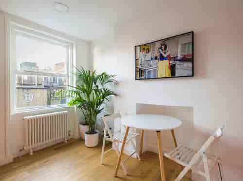 Bright office meeting space with round table, ideal for brainstorming and casual discussions.