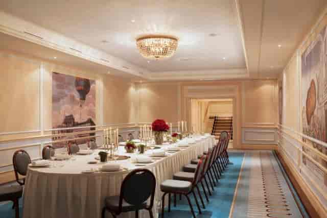 Elegant banquet room with round table, fine china, ideal for corporate meetings and gatherings.