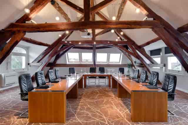 Spacious meeting room with wooden beams at Salon Bourgogne, ideal for strategic planning.