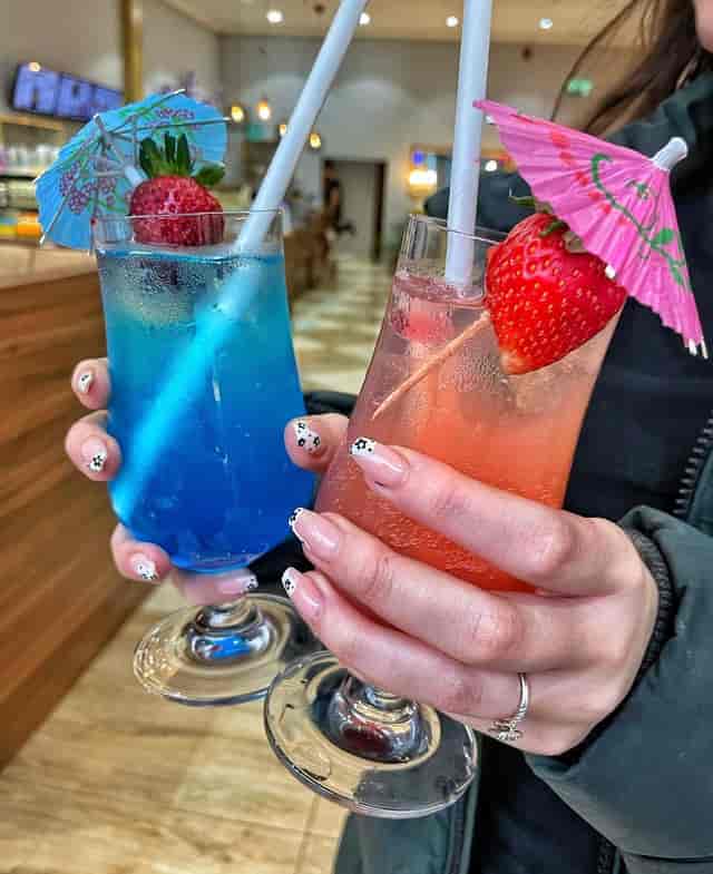 Vibrant blue and pink cocktails with fruit garnishes for festive events and gatherings.