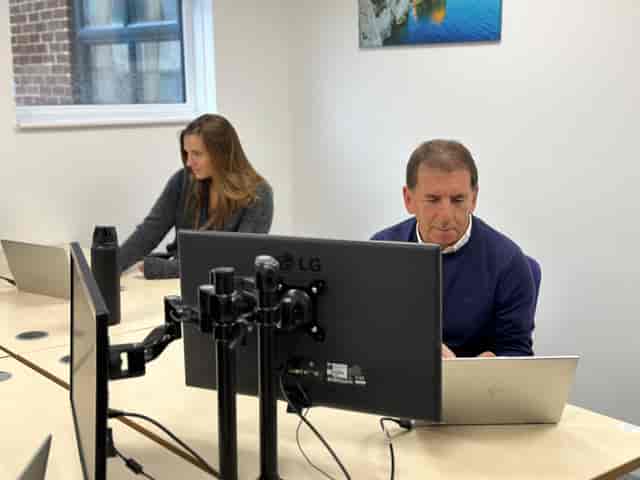 Modern meeting space with professionals working, ideal for hybrid meetings and collaboration.