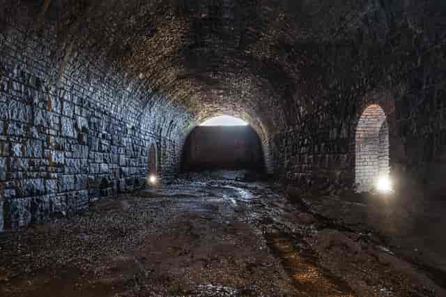 Disused railway tunnel with textured stone walls, perfect for atmospheric events.