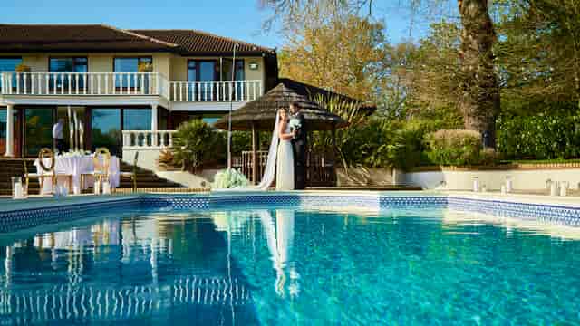 Elegant outdoor wedding venue with serene pool and lush greenery at The Villa Mansion.