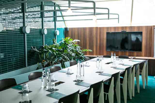 Modern conference room at Yalo Hotel, featuring a long table and advanced presentation screen.