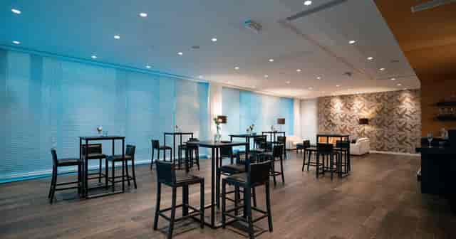 Modern event space Rijvissche with high-top tables, perfect for networking and receptions.