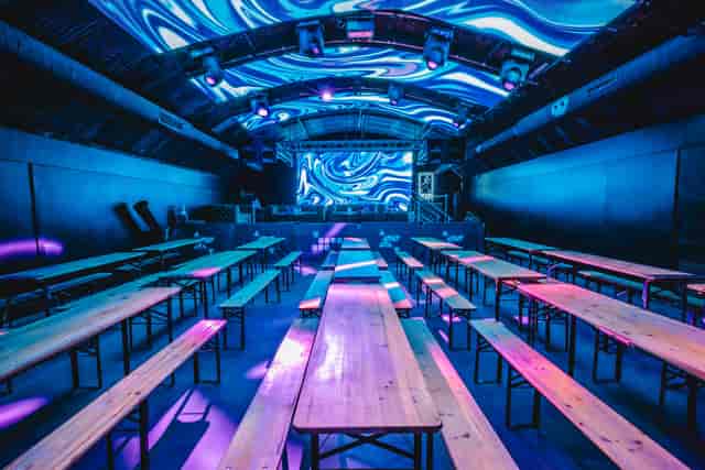 Fire Mirror Arch event space with communal tables, ideal for presentations and gatherings.