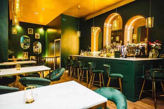 Stylish Tabula Rasa Bar with green walls, ideal for networking events and gatherings.