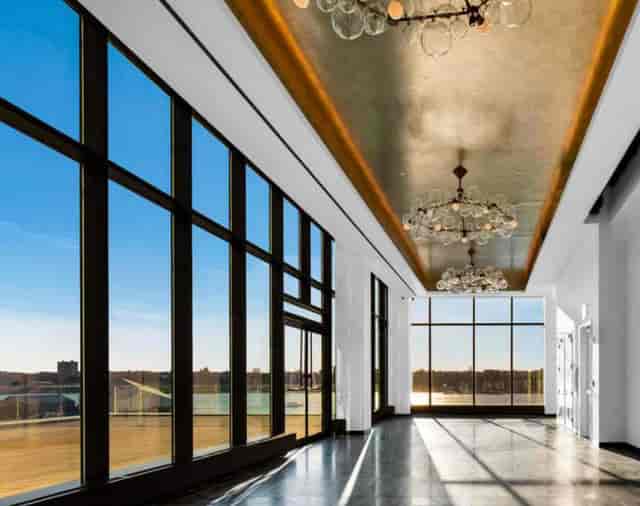 Spacious event venue with large windows and chandeliers for corporate meetings and gatherings.