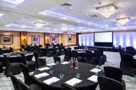 Buckholt Suite at Delta Hotels: elegant corporate event space with round tables and stage.