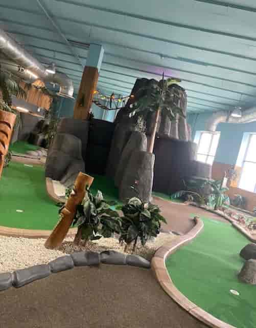 Vibrant indoor mini-golf venue with lush greenery for events in Birmingham.
