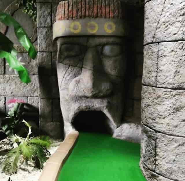 Jungle Rumble Birmingham mini-golf entrance with stone face for unique team-building events.