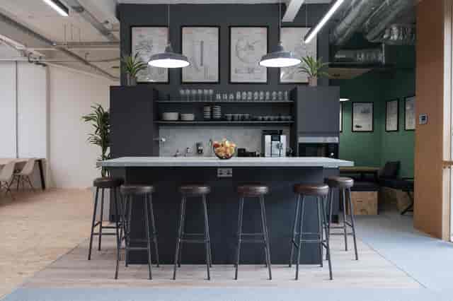 Modern networking space in FOMO House with sleek bar counter and greenery.