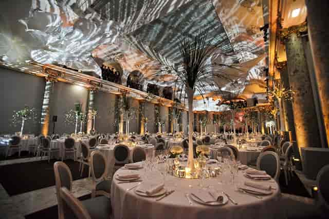 Elegant event space with round tables and dynamic lighting for weddings and corporate events.