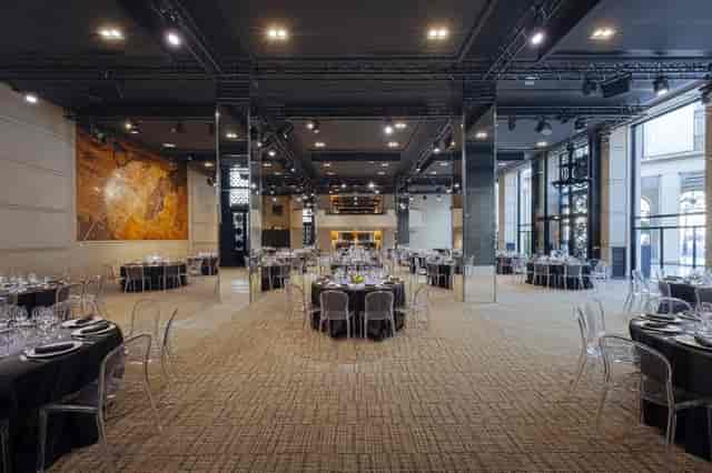 Modern event venue with elegant round tables, ideal for corporate meetings and receptions.