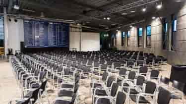 Spacious expo venue with black chairs, ready for presentations and networking events.