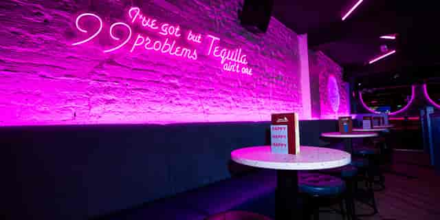 Vibrant event space with stylish seating and neon signage at Tequila Mockingbird.