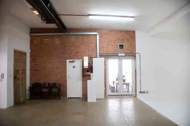 Versatile event space in Bow Bunker, East London with exposed brick wall for meetings.