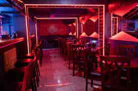 Vibrant cocktail bar lounge with neon lighting, perfect for parties and networking events.