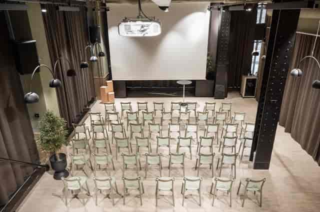 Event space in Provence with arranged chairs, projector, and welcoming lighting.