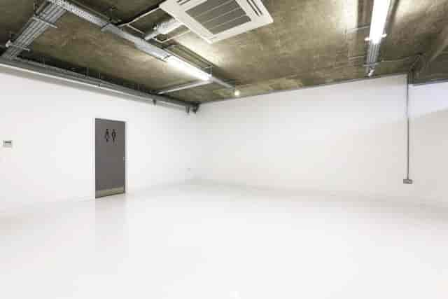 Spacious minimalist event venue with white walls and polished floor at LOCK Studios.