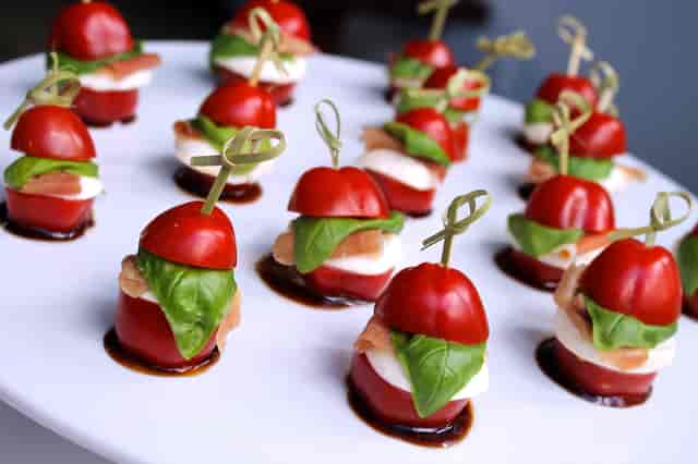 Gourmet appetizer platter with cherry tomatoes, ideal for upscale events and banquets.