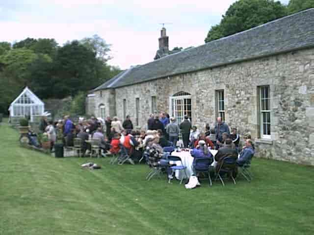 Kirknewton House Stables outdoor networking event with charming stone backdrop and lush lawn.