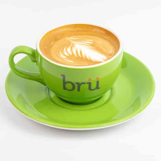 Vibrant green coffee cup with latte art for networking events and meetings.