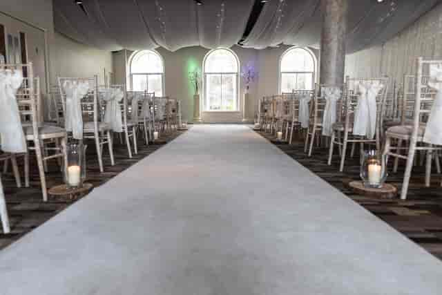 Elegant wedding setup at Eskmills Venue with white-sashed chairs and soft lighting.