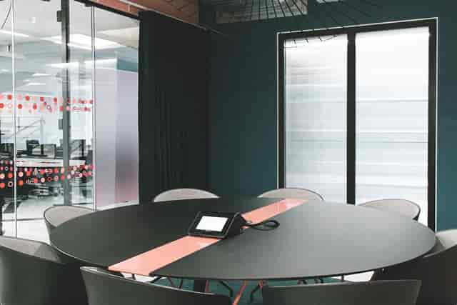Modern meeting room with round table, ideal for conferences and presentations.