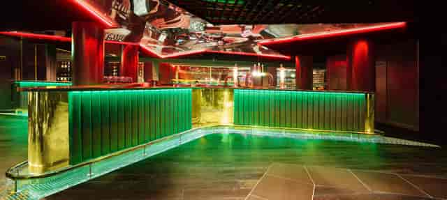Heineken Sky Lounge at AO Arena: modern bar with green accents for networking events.
