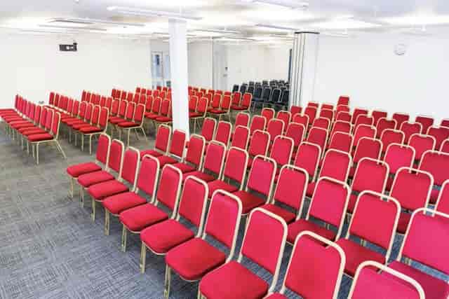 Emerald Suite in The Rock Tower: bright event space with red chairs for conferences.