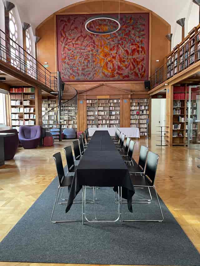 Art Deco library meeting space with elegant table, ideal for workshops and gatherings.