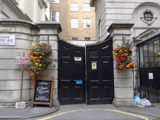 Ornate gates and vibrant flowers at The Old Bank of England garden venue for events.