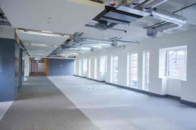 Spacious event space with large windows for corporate meetings and creative workshops.
