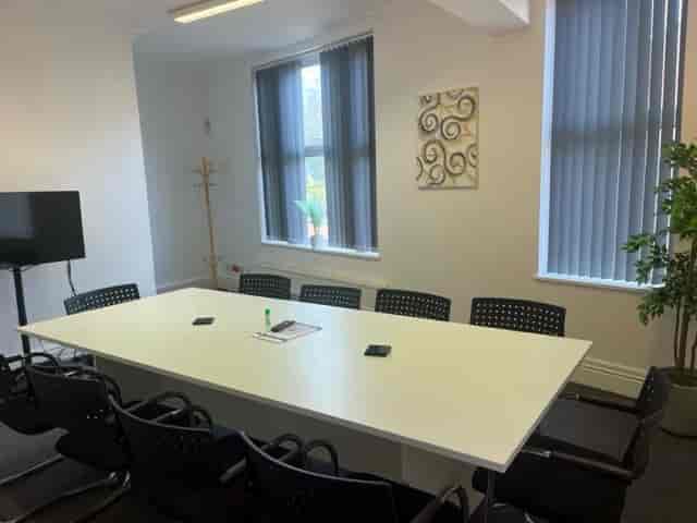 Modern meeting room in Hamill House with large white table, ideal for collaboration.