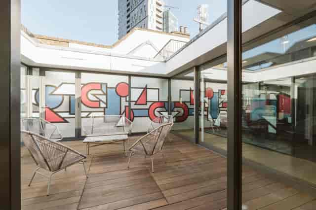 Modern meeting space with vibrant mural at Sky Guild Gaming Centre for creative events.