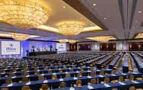 Grand Ballroom at Embassy Suites Houston, elegant chandeliers, corporate conference setup.