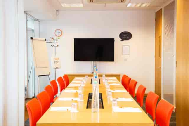 Meeting room in The Studio Leeds with bright orange chairs for workshops and collaboration.