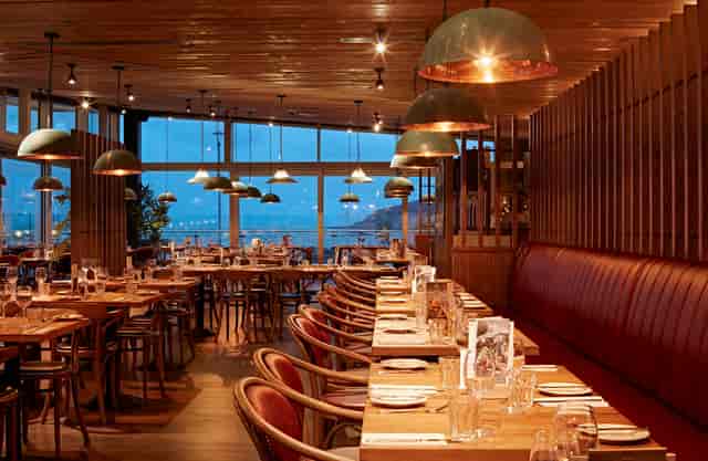 Modern restaurant interior with warm lighting, ideal for corporate events and gatherings.