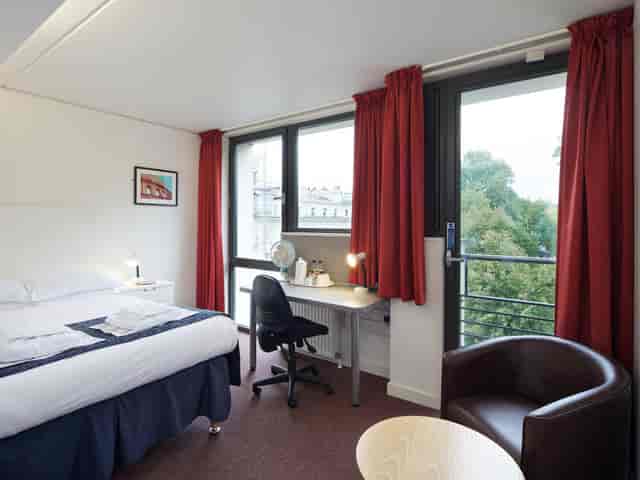 Business hotel room at Celesta Venues, featuring a comfortable bed and workspace.