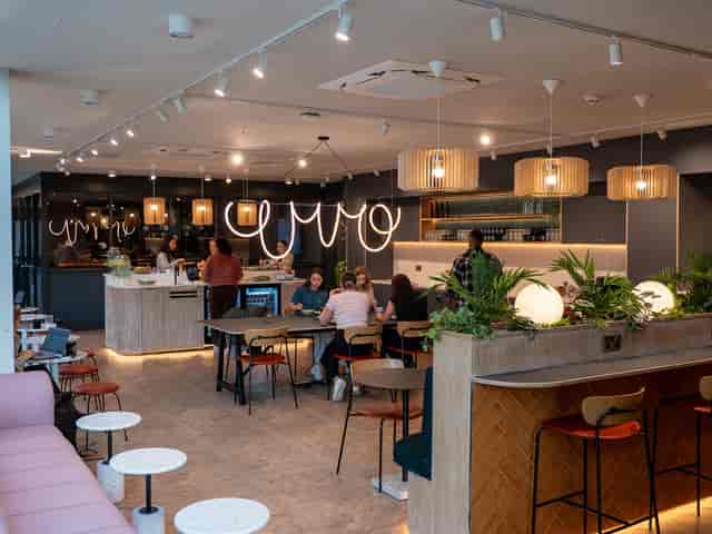 Modern meeting room with warm lighting, ideal for networking and casual events.