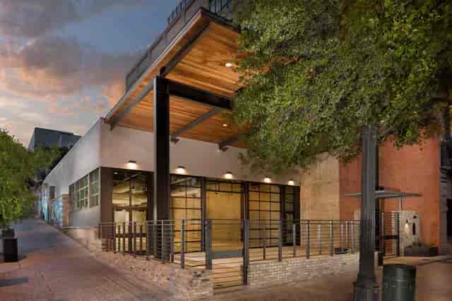 Modern event venue with glass doors and wooden overhang for corporate meetings and gatherings.