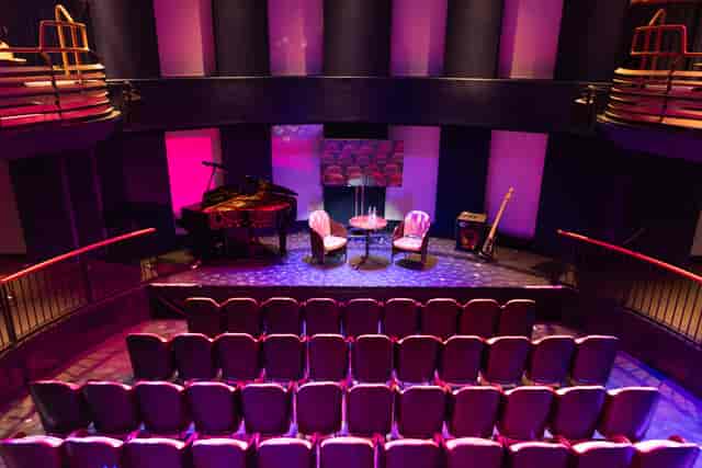 Intimate event space with elegant decor for corporate events and performances.