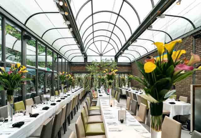 Elegant dining table in bright event space for weddings and corporate dinners.