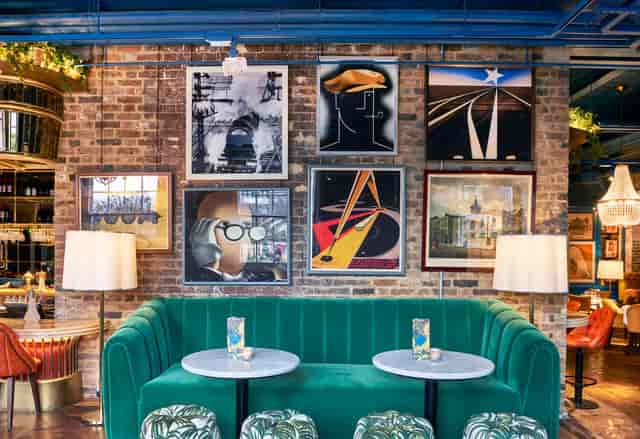 Stylish event space with green seating and modern art, ideal for networking events.
