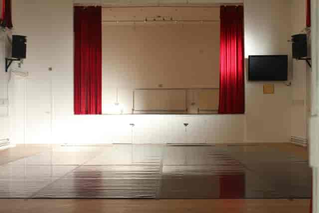 Versatile event space with polished floor and stage for corporate and social events.