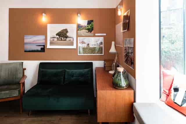 Cozy Loft Studio meeting space with green sofa, perfect for brainstorming sessions.