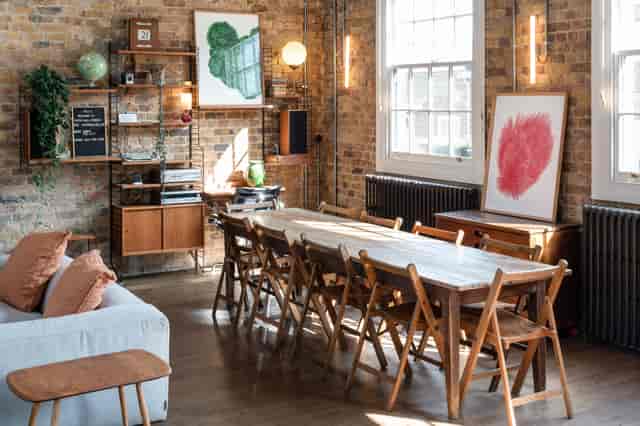Stylish Loft Studio meeting space with wooden table, perfect for collaboration sessions.