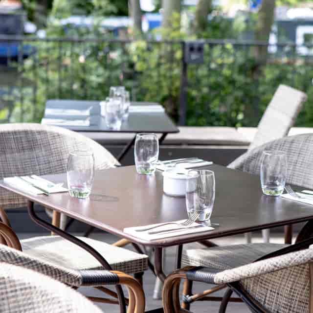 Outdoor terrace dining area with polished glassware, ideal for events and networking.