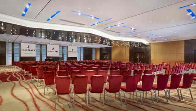 Conference room at Plaza Suites, London with plush red chairs for corporate events.